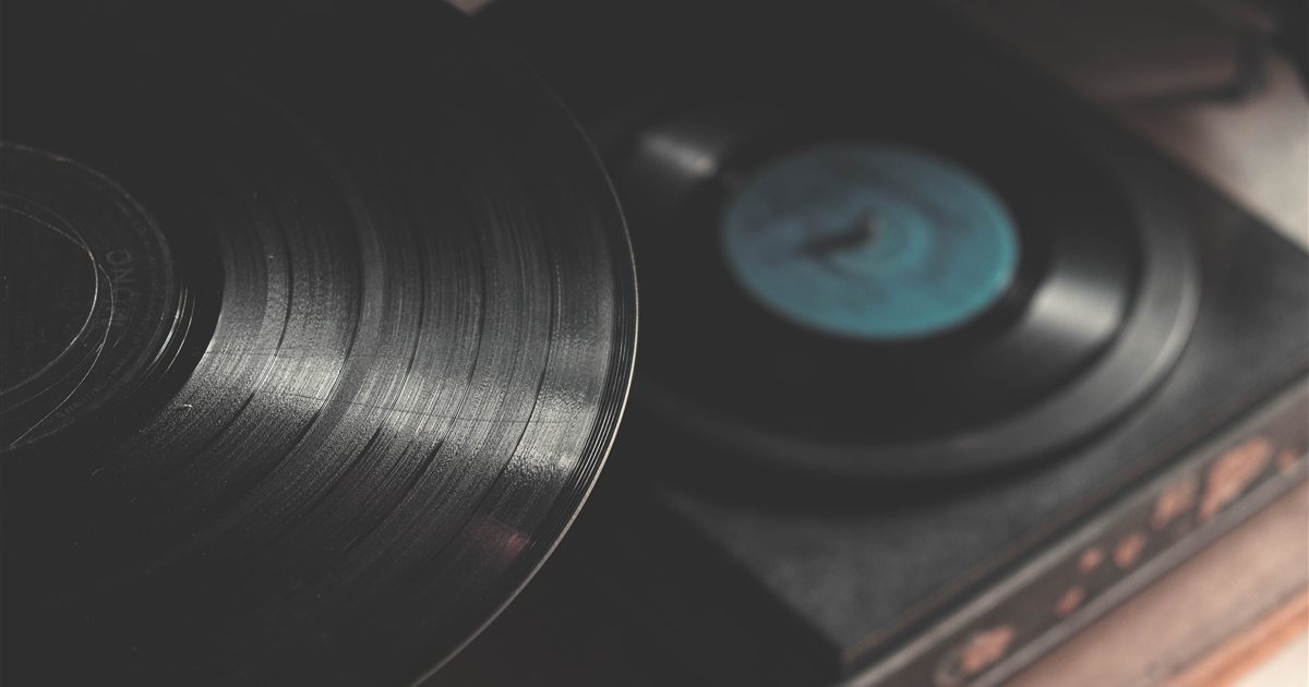 Close-up of a black vinyl record beside a turntable, illustrating the licences Singapore businesses need to play music in venues and use it in marketing videos.