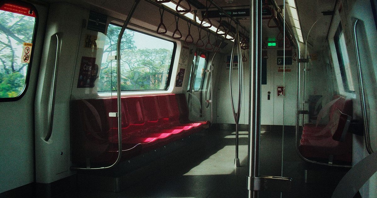 Interior of an empty Singapore MRT train with red seats and poster panels beside the windows, illustrating the rules for advertising on trains, buses, taxis and company vehicles in Singapore.