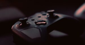 Close-up of a dark, unbranded game controller in low light, illustrating the rules on advertising video games in Singapore.