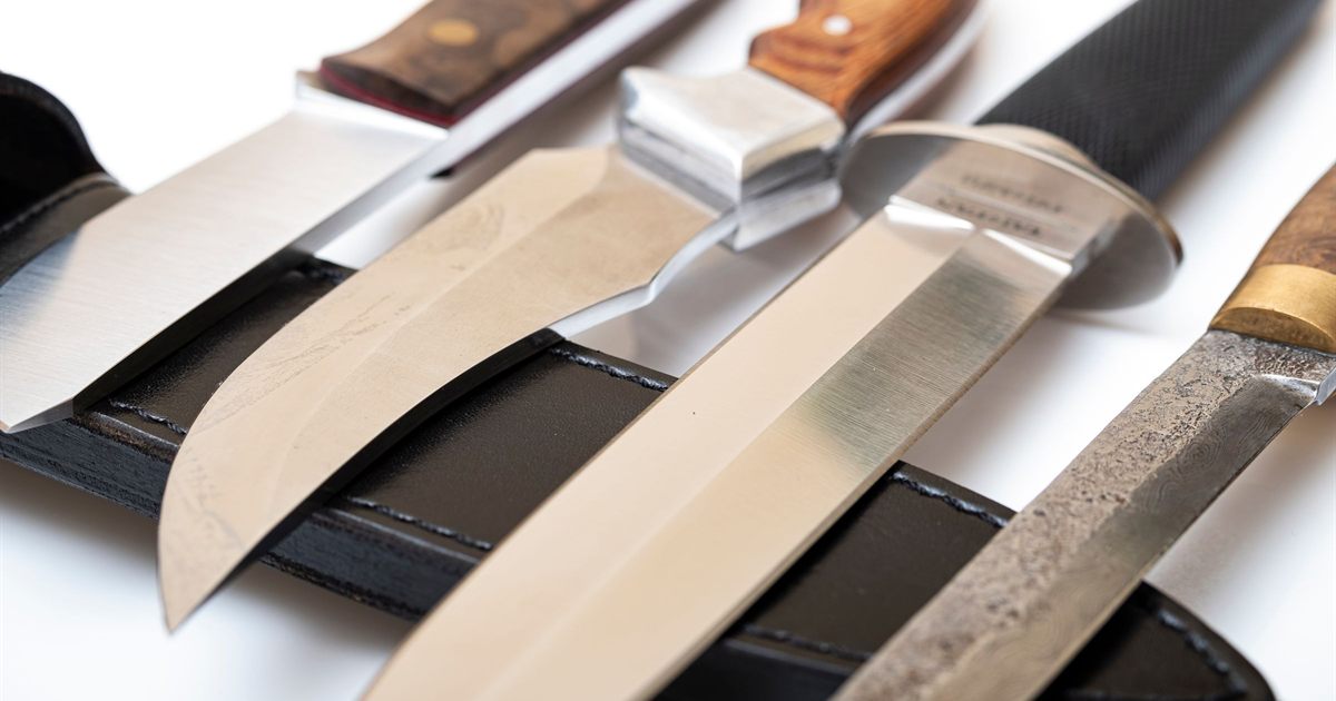 A row of fixed-blade outdoor knives with wooden and rubber handles resting on a black leather sheath, illustrating the rules for listing knives and other regulated items online in Singapore.